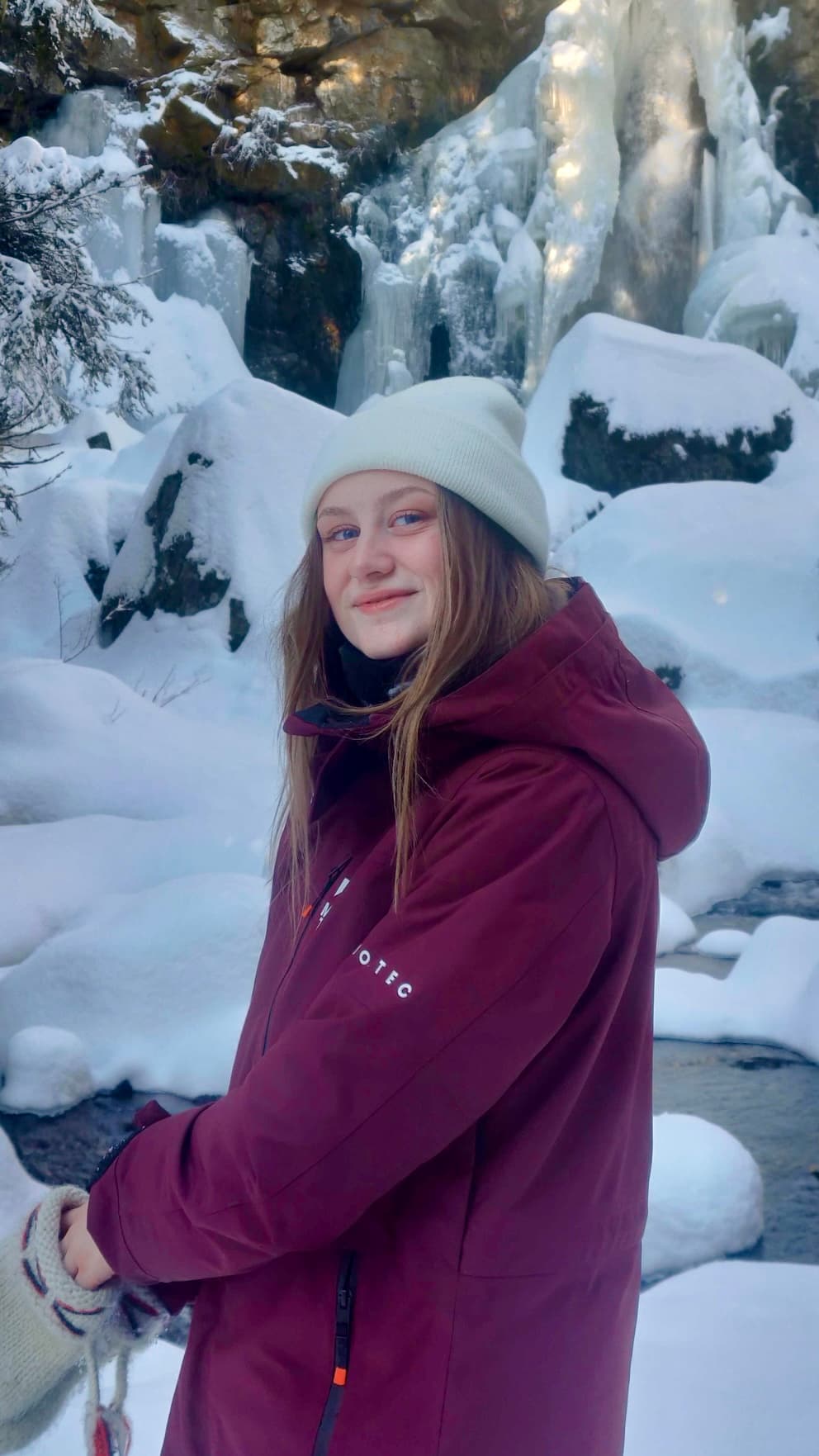 Aurora Olsson smiling in a snowy winter landscape