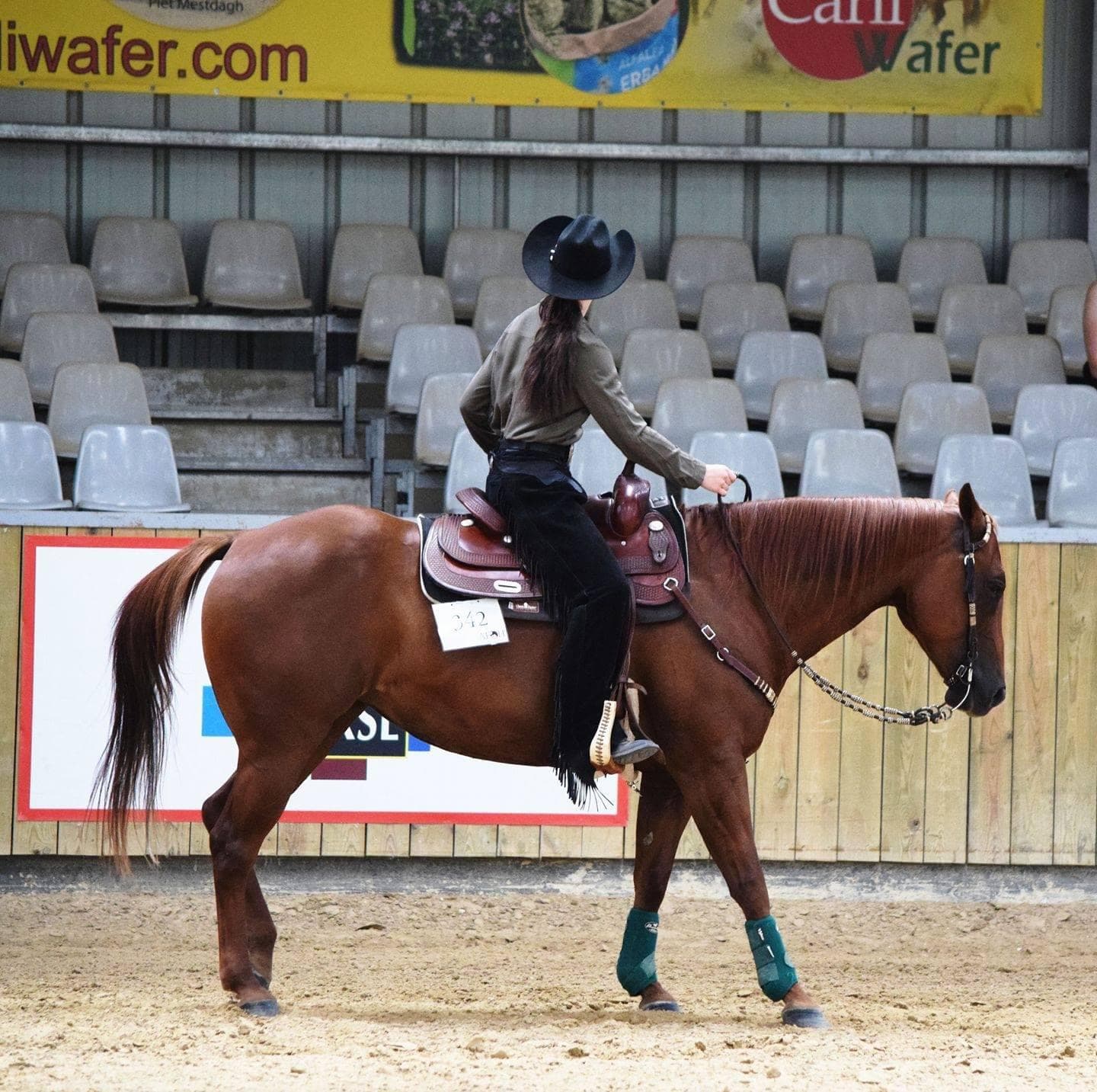 Aurora Olsson riding a chestnut horse in western competition attire